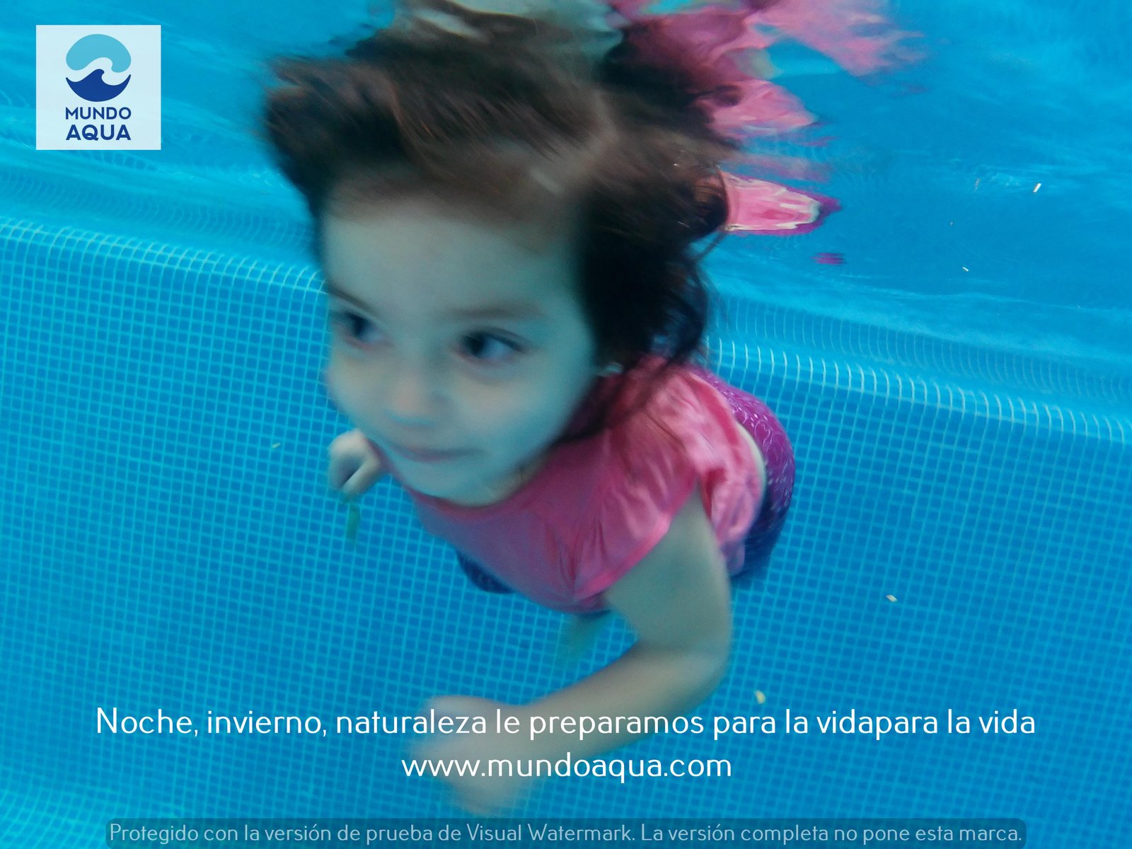 Niña pequeña feliz en clases MundoAqua nadando con dominio y autonomía hacia la cámara